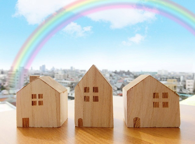 虹のかかった空と家の模型
